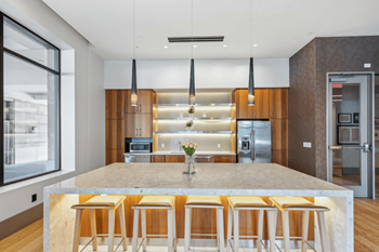 A modern kitchen with a large island and wooden bar stools.